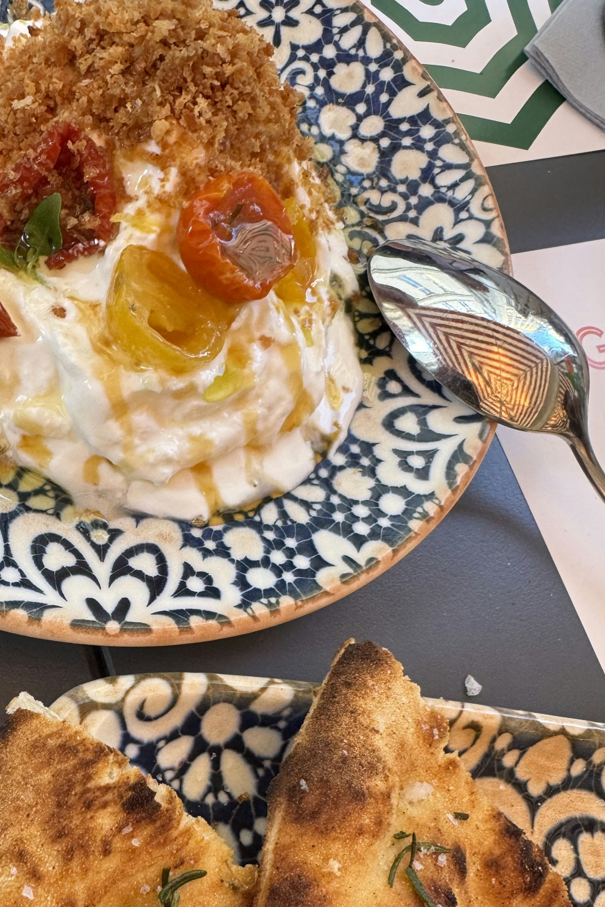 Stracciatella di Bufala mit Limonen-Olivenöl, Honig, Chili, Panko, eingelegten Tomaten und Basilikum, dazu gibt es